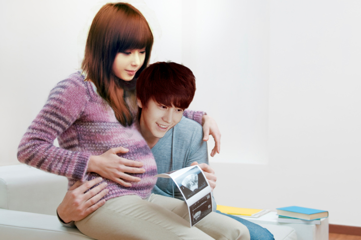 Happy pregnant young couple with baby sonogram